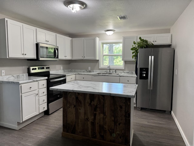 251 Grouse Trl, Pocahontas, AR 72455 - kitchen featuring appliances with stainless steel finishes, a sink, dark wood-style flooring, white cabinets, and baseboards