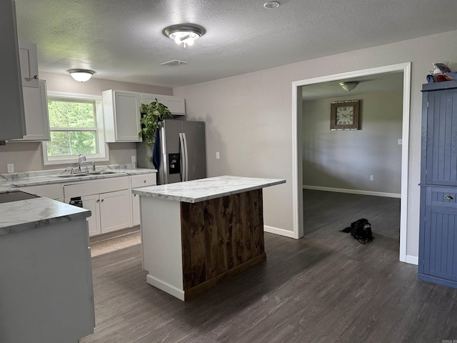 251 Grouse Trl, Pocahontas, AR 72455 - kitchen featuring stainless steel refrigerator with ice dispenser, a sink, dark wood finished floors, a center island, and a textured ceiling