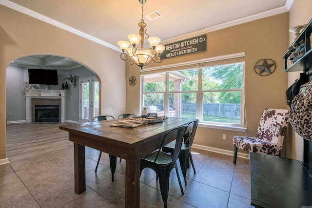 3407 Hemlock Cv, Benton, AR 72015 - tiled dining space featuring ornamental molding, a chandelier, arched walkways, healthy amount of natural light, and baseboards