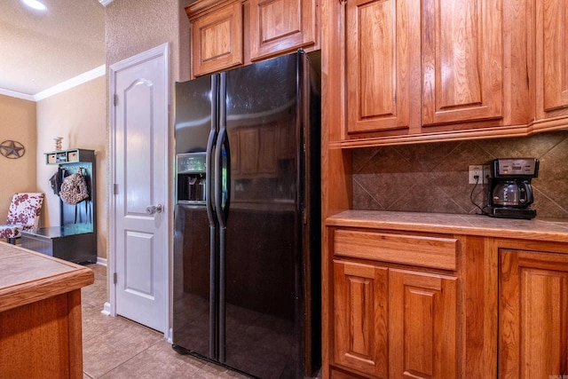 3407 Hemlock Cv, Benton, AR 72015 - kitchen featuring black fridge, ornamental molding, brown cabinets, decorative backsplash, and light tile patterned floors