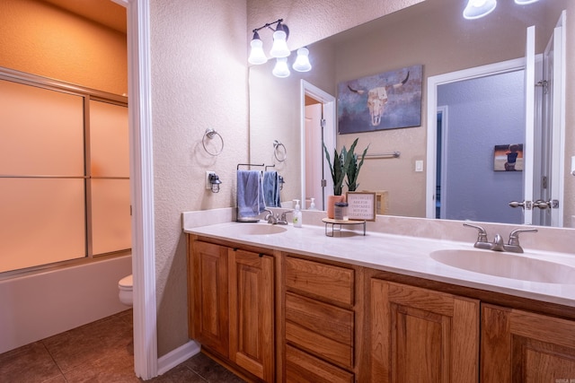 3407 Hemlock Cv, Benton, AR 72015 - bathroom featuring a textured wall, tile patterned floors, toilet, double vanity, and shower / bath combination with glass door