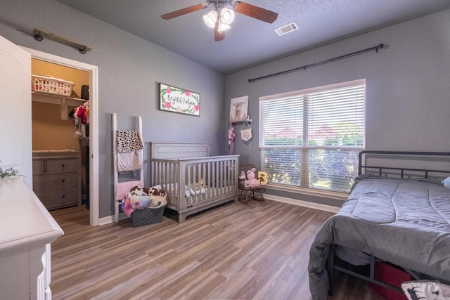 3407 Hemlock Cv, Benton, AR 72015 - bedroom featuring light wood-type flooring, baseboards, a spacious closet, a ceiling fan, and a closet