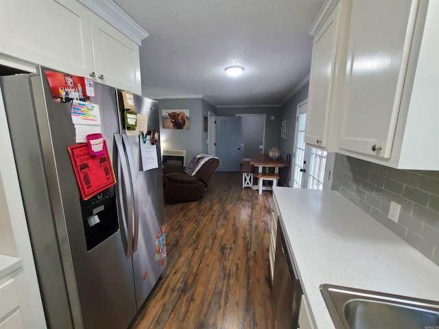 690 Redwood Dr, Piggott, AR 72454 - kitchen with stainless steel appliances, dark wood-type flooring, white cabinetry, light countertops, and crown molding