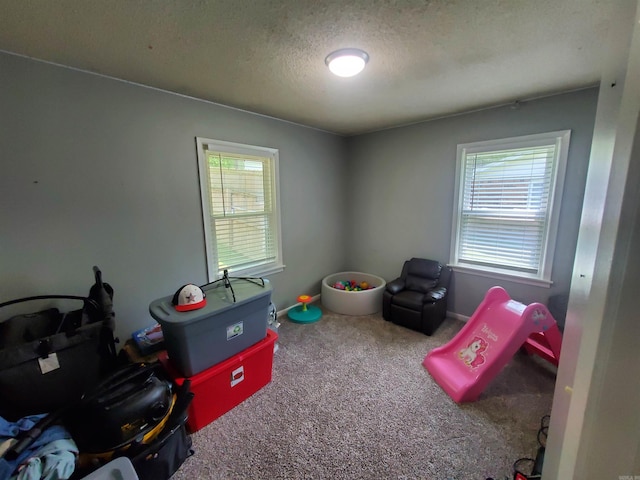 690 Redwood Dr, Piggott, AR 72454 - recreation room featuring carpet flooring, a textured ceiling, and baseboards