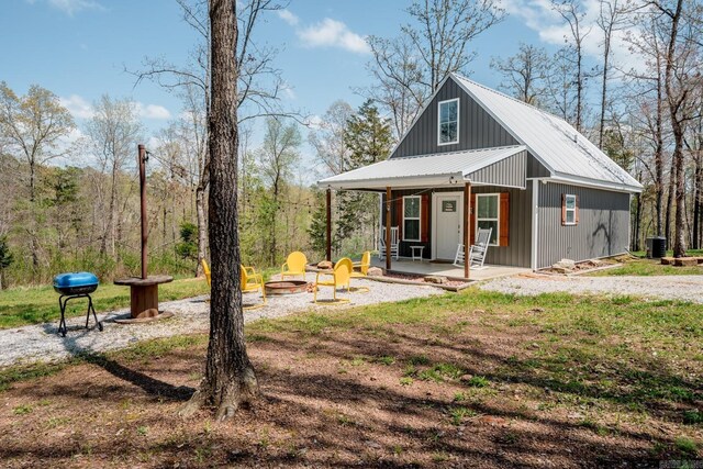 948 Sunny Slope Rd, Edgemont, AR 72044 - view of front of home with a fire pit, metal roof, central AC unit, and covered porch
