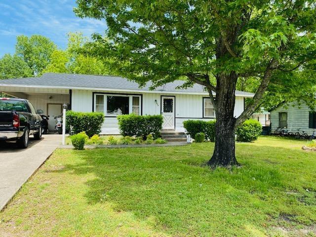 view of front of property featuring an attached carport, driveway, and a front yard