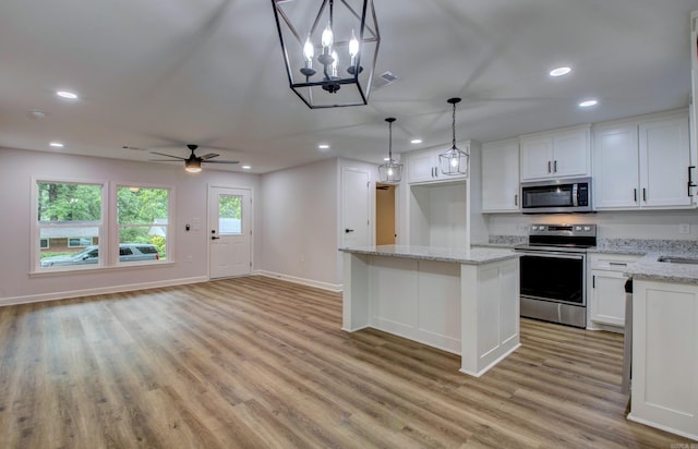 1114 Edgehill Dr, Benton, AR 72015 - kitchen featuring stainless steel appliances, light wood-style flooring, white cabinetry, a kitchen island, and baseboards