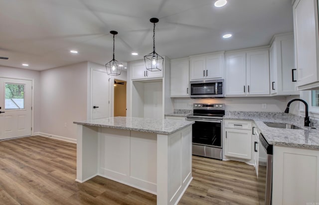 1114 Edgehill Dr, Benton, AR 72015 - kitchen featuring stainless steel appliances, a sink, a kitchen island, light wood-type flooring, and recessed lighting
