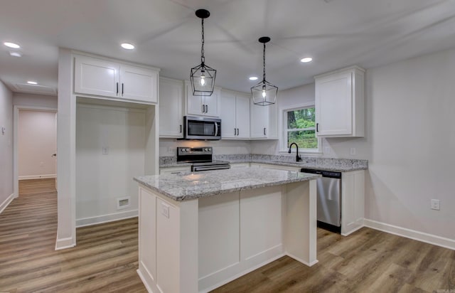 1114 Edgehill Dr, Benton, AR 72015 - kitchen with appliances with stainless steel finishes, white cabinets, a center island, a sink, and light wood finished floors