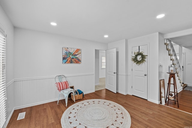 entrance foyer featuring wood finished floors, wainscoting, recessed lighting, and stairs