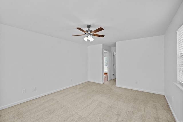 carpeted empty room featuring ceiling fan and baseboards