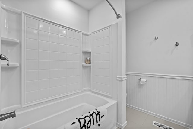 full bathroom featuring tub / shower combination, a wainscoted wall, and tile patterned floors