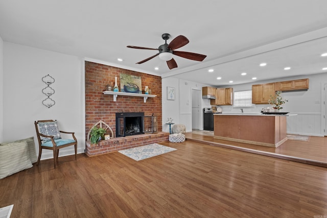 unfurnished living room with light wood-style floors, a ceiling fan, recessed lighting, and a brick fireplace