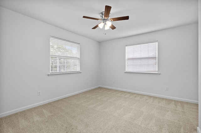empty room featuring carpet, baseboards, and a ceiling fan