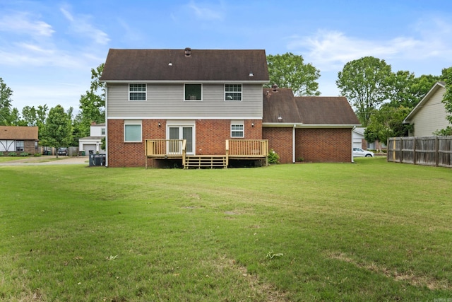 rear view of property featuring brick siding and a wooden deck