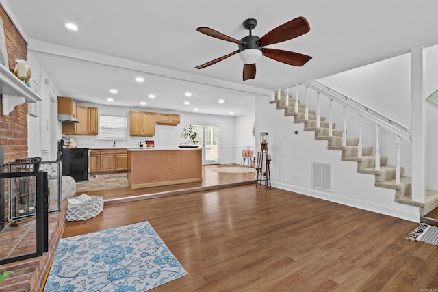 living area featuring light wood finished floors, stairs, a ceiling fan, recessed lighting, and baseboards