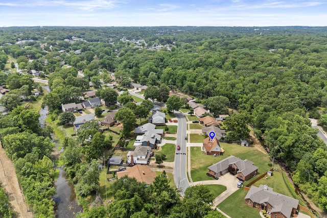 aerial overview of property's location with a heavily wooded area and nearby suburban area