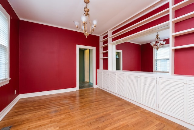 111 Thayer St, Little Rock, AR 72205 - unfurnished room featuring a chandelier, built in features, plenty of natural light, ornamental molding, and baseboards