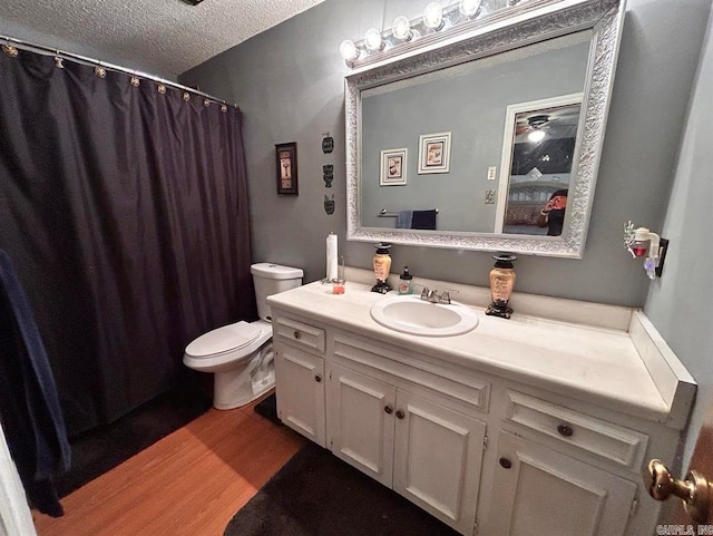 9314 Timber Valley Rd, Little Rock, AR 72204 - bathroom featuring wood finished floors, toilet, a textured ceiling, vanity, and curtained shower