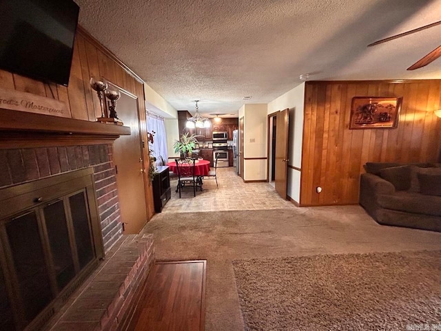 9314 Timber Valley Rd, Little Rock, AR 72204 - living area featuring light colored carpet, a fireplace, wood walls, a textured ceiling, and a chandelier