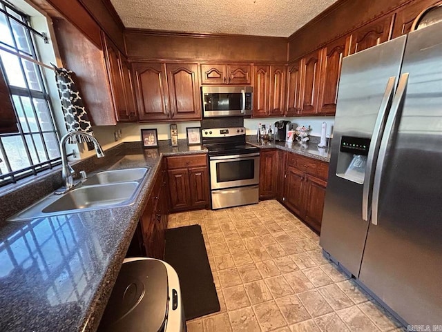 9314 Timber Valley Rd, Little Rock, AR 72204 - kitchen with appliances with stainless steel finishes, a sink, a textured ceiling, dark countertops, and crown molding