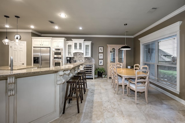 126 Manitou Dr, Maumelle, AR 72113 - dining room with wine cooler, crown molding, baseboards, and recessed lighting