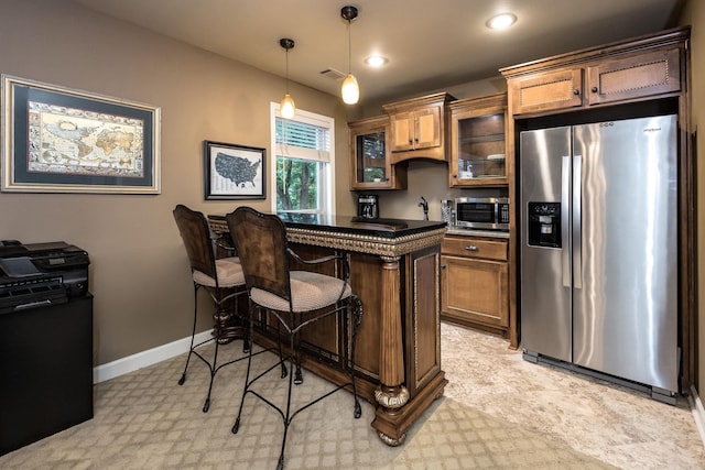 126 Manitou Dr, Maumelle, AR 72113 - kitchen with stainless steel appliances, a kitchen bar, glass insert cabinets, hanging light fixtures, and baseboards