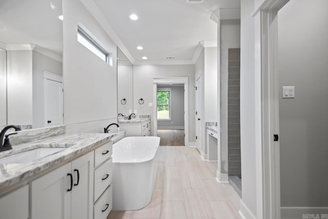 9313 Wooddale Dr, Sherwood, AR 72120 - full bathroom with ornamental molding, baseboards, a freestanding bath, two vanities, and recessed lighting
