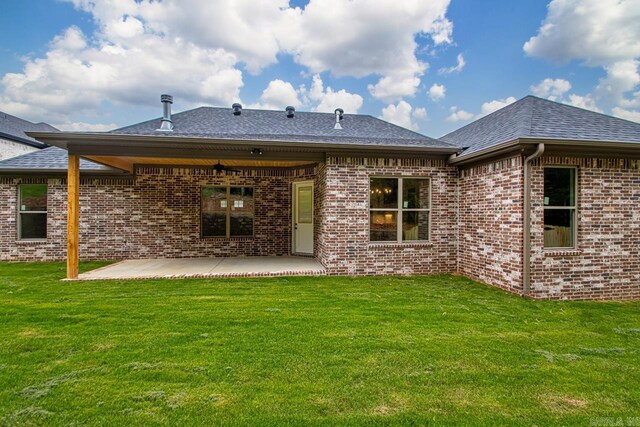 9313 Wooddale Dr, Sherwood, AR 72120 - rear view of house featuring brick siding, a patio, a yard, and roof with shingles