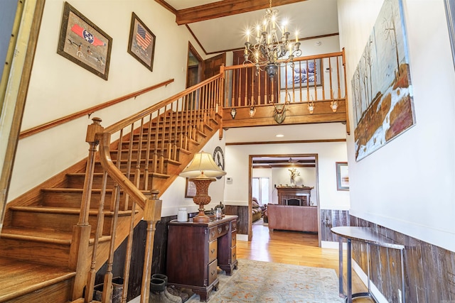 2005 Kingshighway, Weiner, AR 72479 - stairs featuring wood finished floors, a wainscoted wall, crown molding, a fireplace, and a chandelier