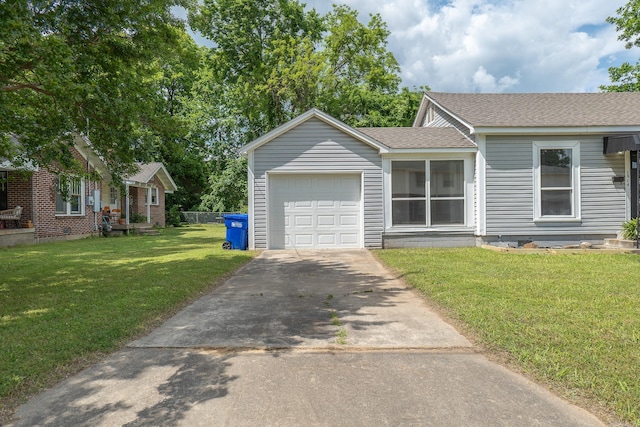 view of front of home featuring an attached garage, driveway, roof with shingles, and a front yard