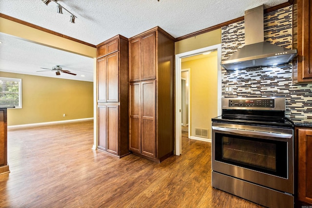 821 Mcadoo St, Little Rock, AR 72205 - kitchen featuring electric stove, wall chimney exhaust hood, dark countertops, a textured ceiling, and dark wood-style floors