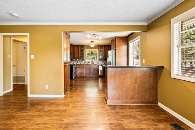 821 Mcadoo St, Little Rock, AR 72205 - kitchen featuring appliances with stainless steel finishes, brown cabinets, dark wood-type flooring, glass insert cabinets, and healthy amount of natural light