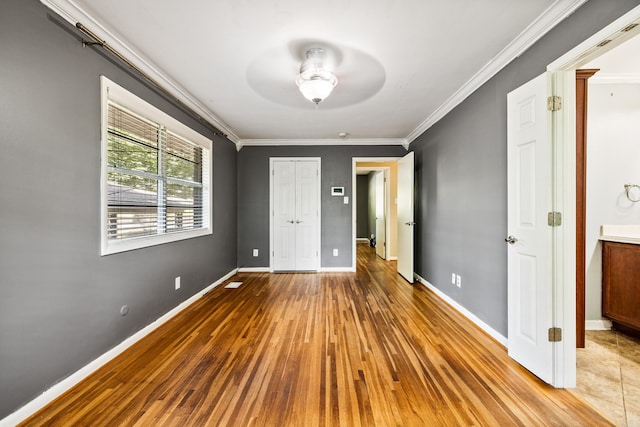 821 Mcadoo St, Little Rock, AR 72205 - unfurnished bedroom with hardwood / wood-style floors, crown molding, baseboards, ceiling fan, and a closet