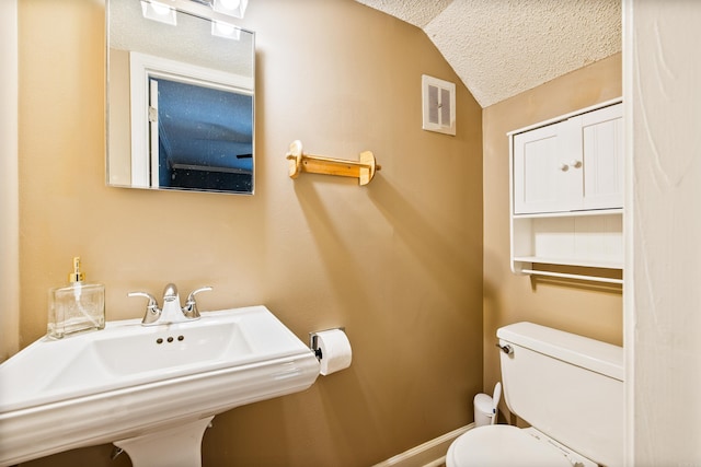 821 Mcadoo St, Little Rock, AR 72205 - bathroom with toilet, lofted ceiling, a textured ceiling, a sink, and baseboards