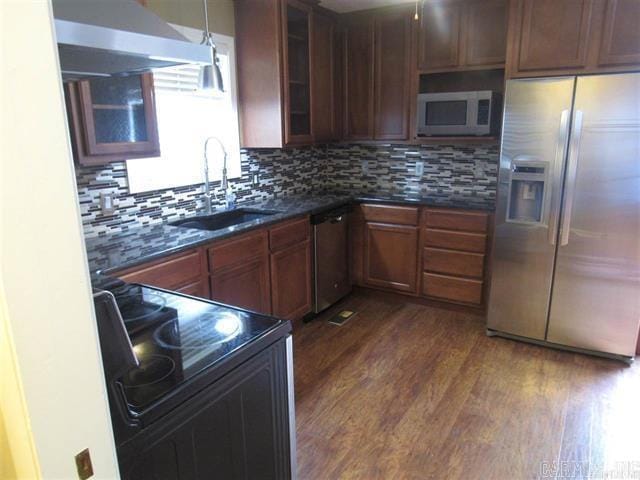 821 Mcadoo St, Little Rock, AR 72205 - kitchen featuring stainless steel appliances, a sink, dark countertops, dark wood-type flooring, and tasteful backsplash