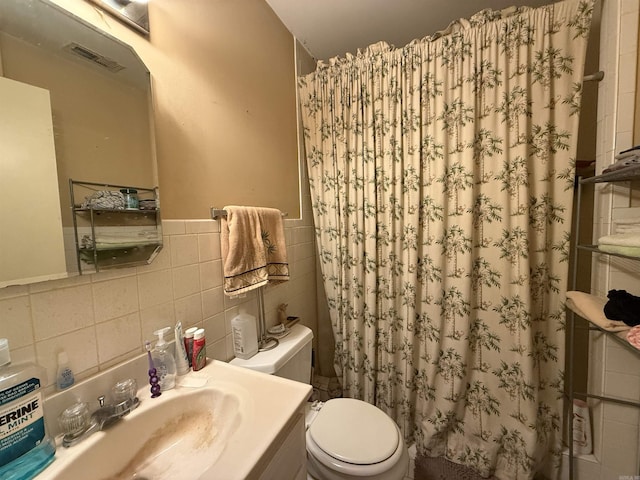 bathroom featuring toilet, tile walls, curtained shower, and vanity