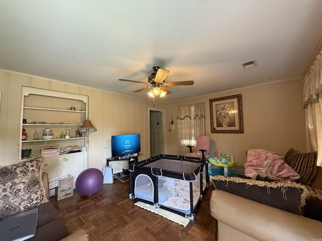 living room featuring ceiling fan and crown molding