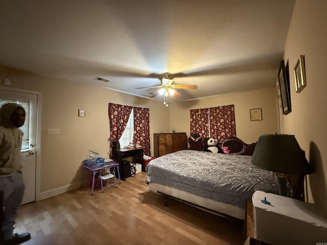 bedroom with wood finished floors, baseboards, and a ceiling fan
