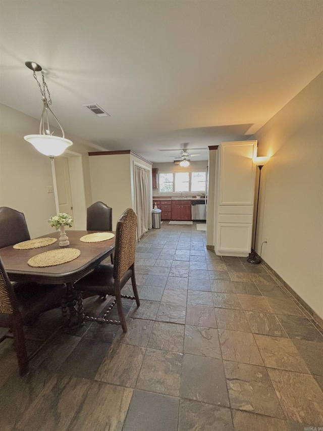 dining room with stone tile flooring, baseboards, and a ceiling fan
