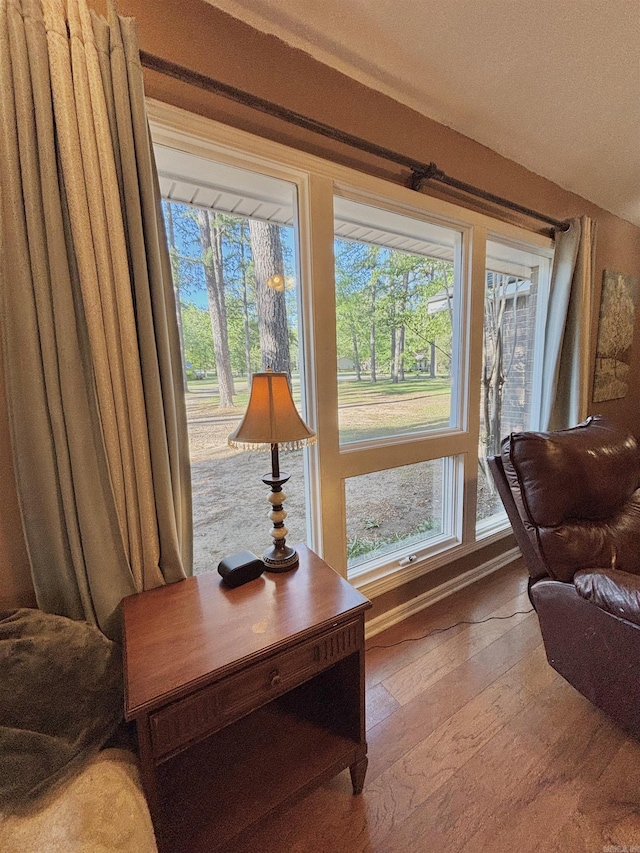 living area with wood-type flooring and baseboards