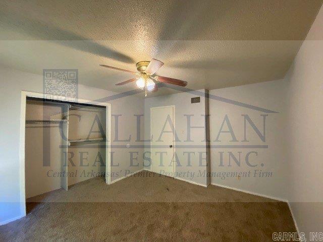 110 Rim Rock Pl, North Little Rock, AR 72116 - unfurnished bedroom featuring carpet flooring, a closet, a textured ceiling, and a ceiling fan
