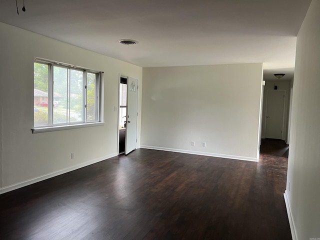 1302 Collins Dr, Pine Bluff, AR 71601 - spare room with dark wood-style floors, healthy amount of natural light, and baseboards