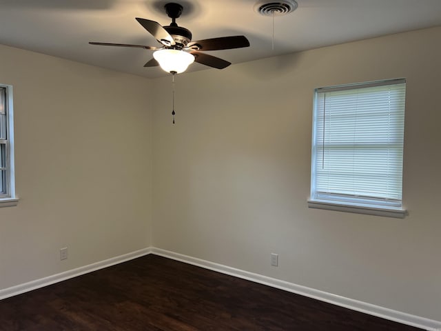 1302 Collins Dr, Pine Bluff, AR 71601 - unfurnished room featuring a ceiling fan, baseboards, and dark wood-style flooring