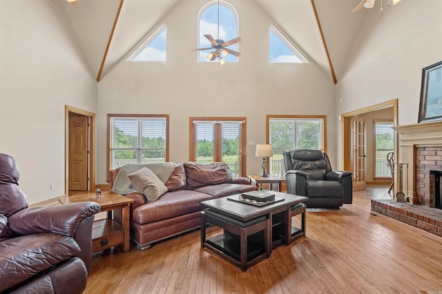 1325 El Dorado, Benton, AR 72019 - living room with a ceiling fan, light wood-style floors, a brick fireplace, high vaulted ceiling, and plenty of natural light