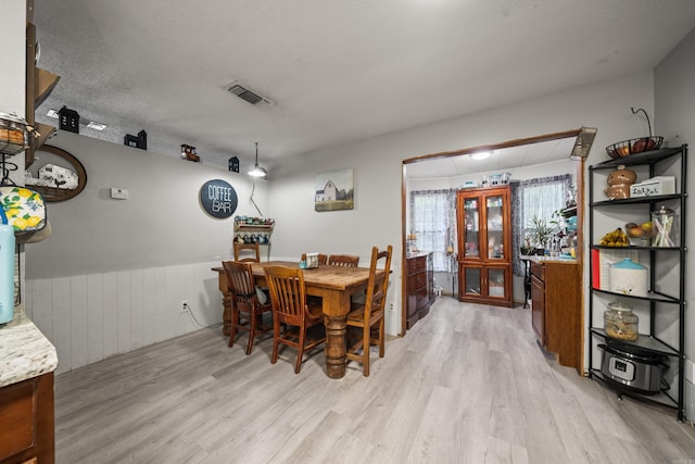 106 Gareth Ct, Hot Springs National Park, AR 71913 - dining space featuring light wood-style floors, wainscoting, wood walls, and a textured ceiling