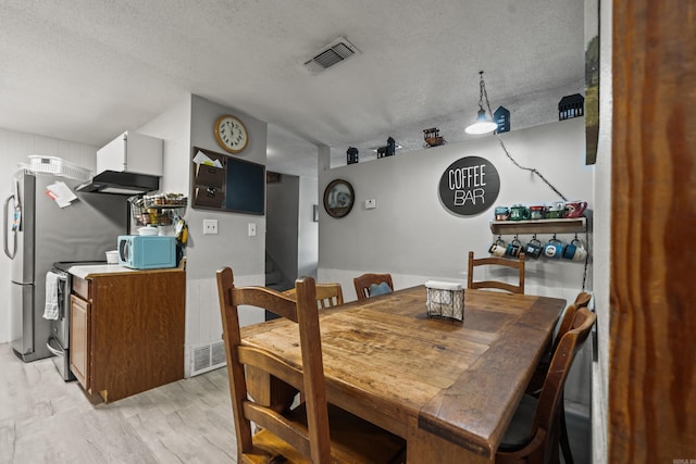 106 Gareth Ct, Hot Springs National Park, AR 71913 - dining space featuring light wood-style flooring, a textured ceiling, and stairs