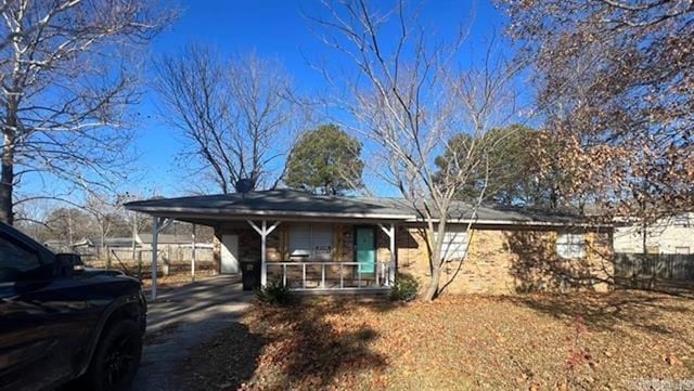 view of front of property featuring an attached carport, fence, and driveway