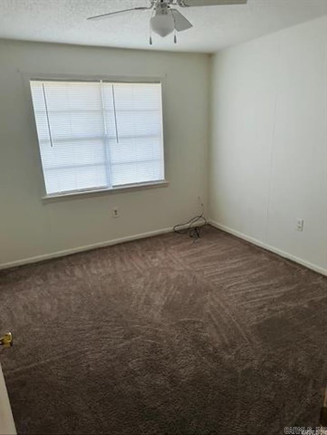 carpeted empty room with a ceiling fan and baseboards