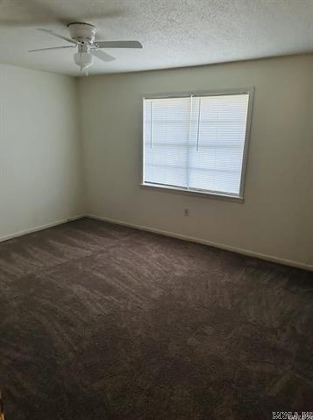 unfurnished room featuring ceiling fan, baseboards, and dark carpet
